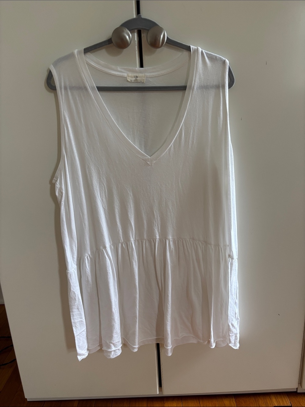 Sleeveless White V‑Neck Peplum Tunic